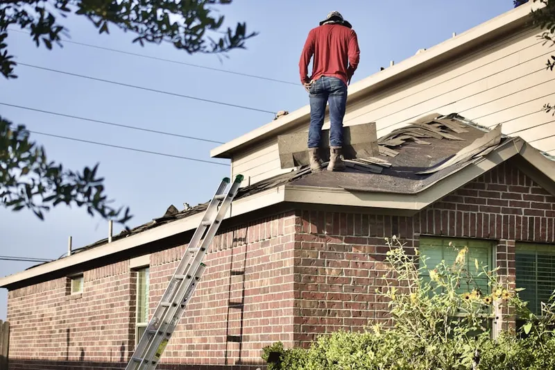 Professional roofer working on a residential roof in Windy Hill